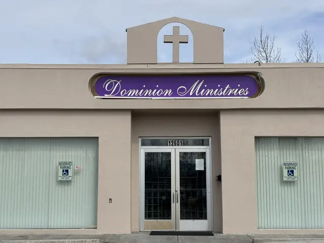 Entrance of a building labeled "Dominion Ministries" with a cross above.